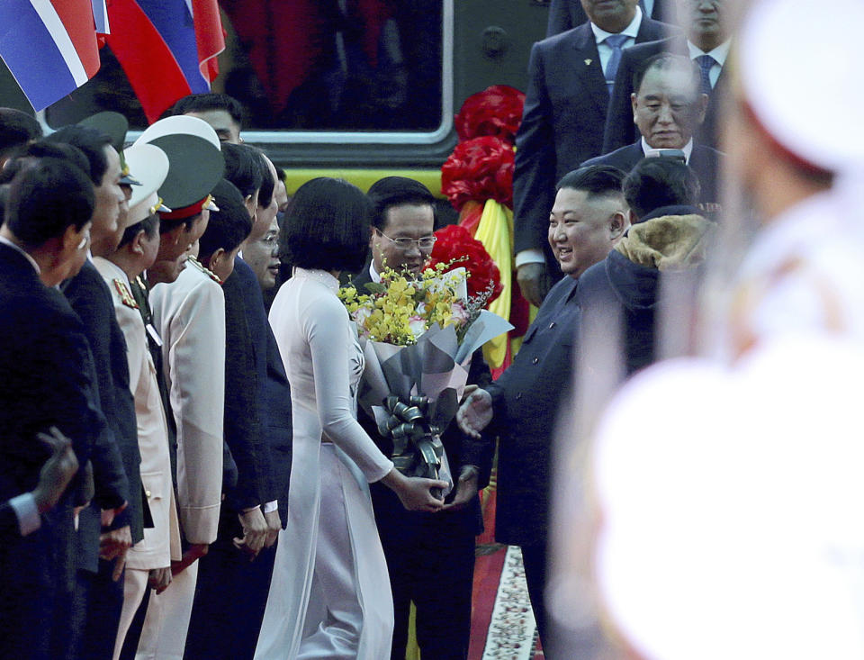 North Korean leader Kim Jong Un, center right, receives a bouquet of flowers upon arrival by train in Dong Dang in Vietnamese border town Tuesday, Feb. 26, 2019, ahead of his second summit with U.S. President Donald Trump. (AP Photo/Minh Hoang)