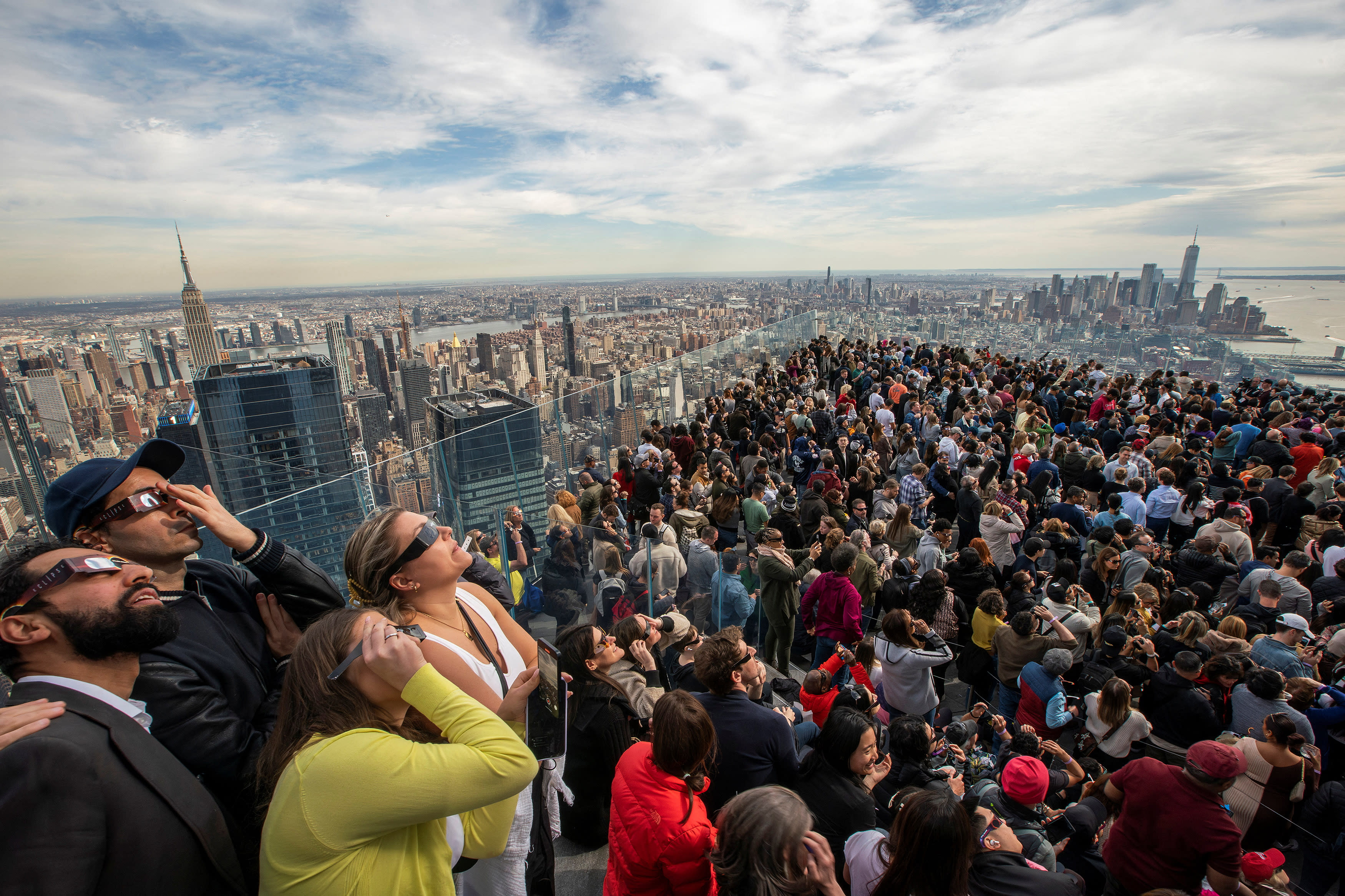 People watch the partial solar eclipse as they gather on the observation deck of Edge at Hudson Yards in New York City, New York on April 8, 2024. (Eduardo Munoz/Reuters)