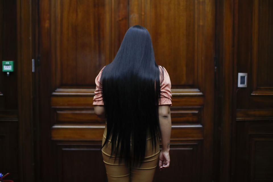 Transgender woman Angeles Rojas enters a room at Banco Nación where she works in Buenos Aires, Argentina, Thursday, Nov. 5, 2020. Rojas, 23, joined the most important public bank in Argentina this year as part of the trans labor quota that is part of the public policies in favor of the LGBT community that the South American country has implemented in the last decade. (AP Photo/Natacha Pisarenko)