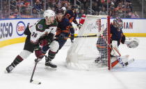 Arizona Coyotes' Christian Fischer (36) is chased by Edmonton Oilers' Ryan Nugent-Hopkins (93) as goalie Stuart Skinner (74) looks for the puck during the first period of an NHL hockey game in Edmonton, Alberta, on Wednesday, Dec. 7, 2022. (Jason Franson/The Canadian Press via AP)