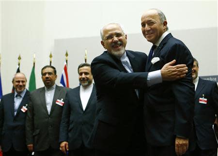 Iranian Foreign Minister Mohammad Javad Zarif (2nd R) hugs French Foreign Minister Laurent Fabius after a ceremony at the United Nations in Geneva November 24, 2013. REUTERS/Denis Balibouse