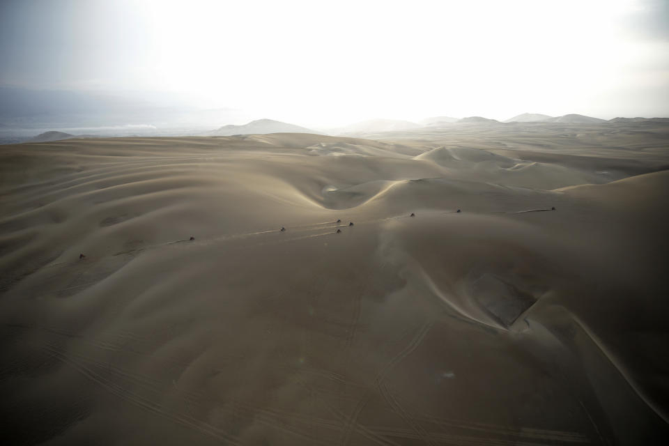 In this Jan. 16, 2019 photo, competitors ride their motorbikes across the dunes during stage nine of the Dakar Rally in Pisco, Peru. (AP Photo/Ricardo Mazalan)