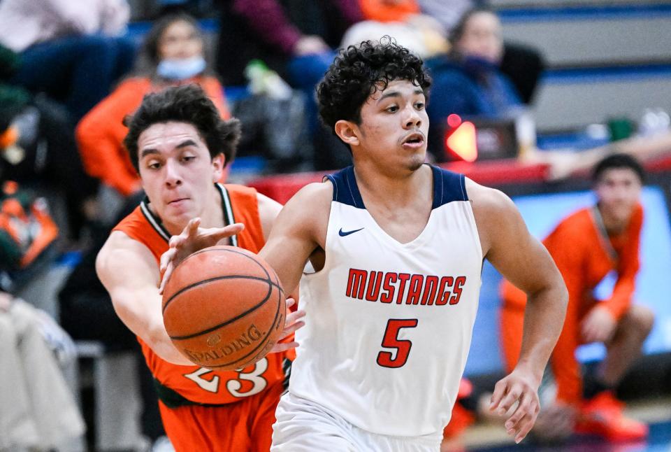 Tulare Western's Damion Bello escapes the swipe of Porterville's Matthew Rivera in boys basketball on Friday, January 14, 2022. 