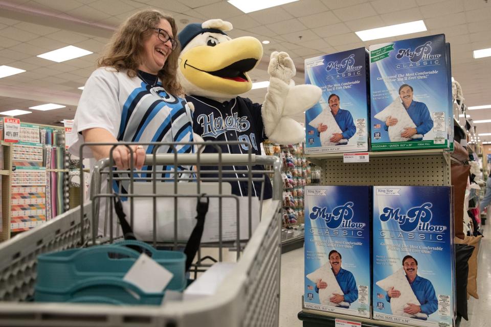 JFK Elementary School librarian Malia Perez laughs with Hooks mascot Sammy during a sponsored shopping trip to the Mardel Christian and Education store for school supplies on Thursday in Corpus Christi.