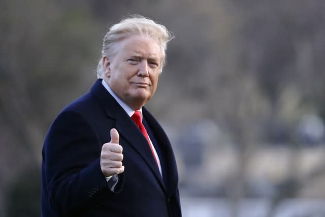 President Donald Trump gestures as he walks to the Oval Office of the White House in Washington