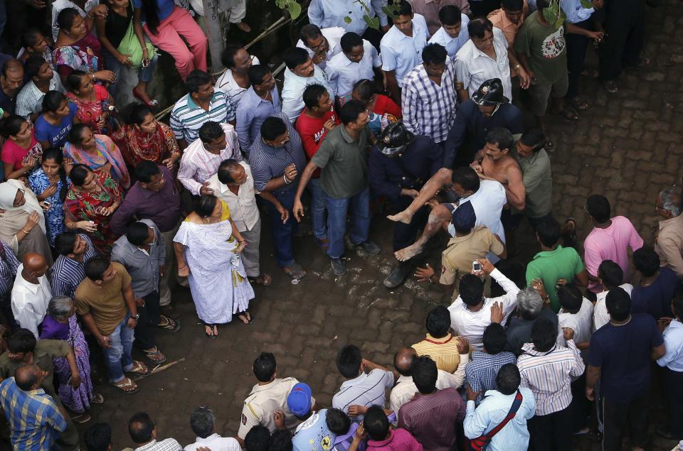 Rescue workers carry a man who was rescued from the rubble at the site of a collapsed residential building in Mumbai September 27, 2013. (REUTERS/Danish Siddiqui)