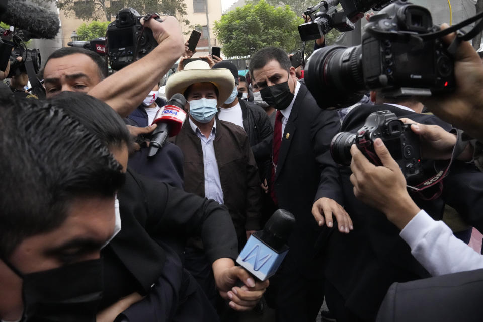 FILE - In this June 15, 2021 file photo, presidential candidate Pedro Castillo is surrounded by journalists as he arrives to his campaign headquarters to give a press conference in Lima, Peru. After more than a month since the election Castillo is expected to be named president, even after opponent Keiko Fujimori has claimed electoral fraud . (AP Photo/Martin Mejia, File)