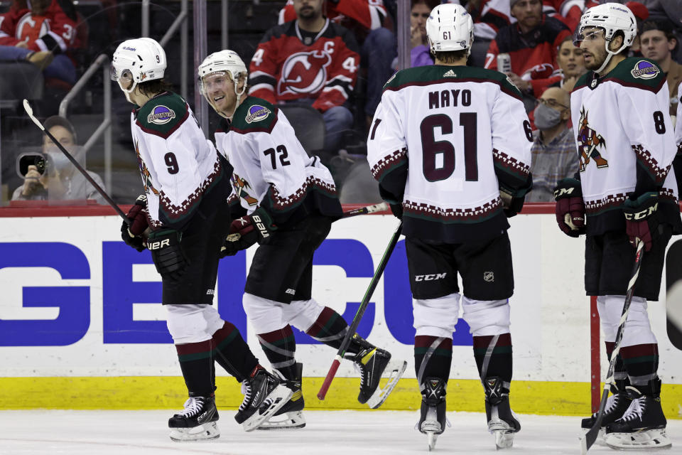 Arizona Coyotes center Travis Boyd (72) celebrates with teammates after scoring a goal against the New Jersey Devils during the second period of an NHL hockey game Wednesday, Jan. 19, 2022, in Newark, N.J. (AP Photo/Adam Hunger)