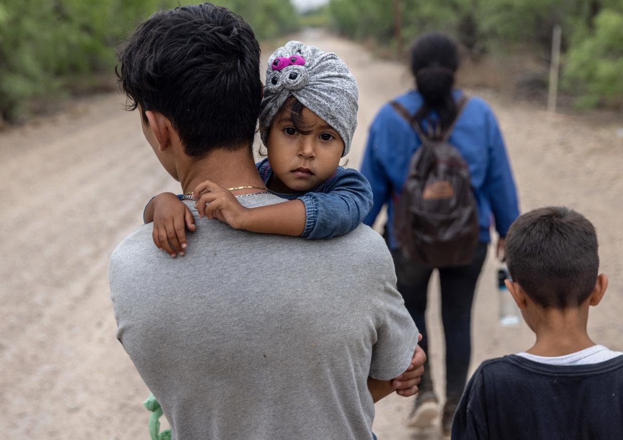 An immigrant child looks back toward Mexico after crossing the border into the United States with her family on April 14, 2021, in La Joya, Texas.