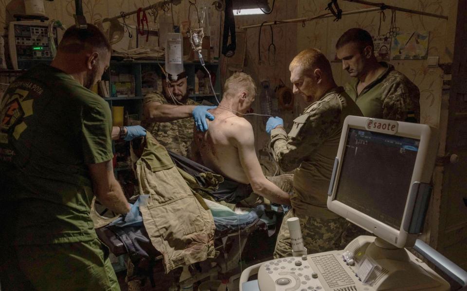 A wounded Ukrainian soldier is treated by Ukrainian military medics in a Ukrainian stabilisation point in an undisclosed location near Bakhmut