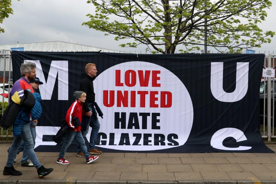 Fans walk past a flag reading 'Love United, Hate Glazers' as they arrive prior to kick off of the match between Manchester United and Brentford at Old Trafford (Getty Images)