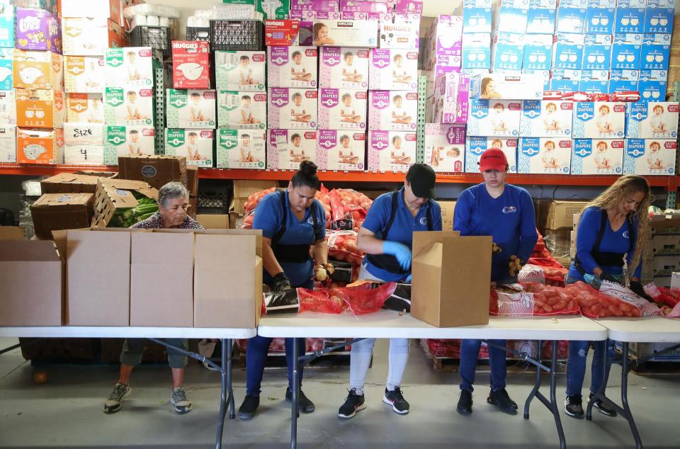 Volunteers and staff pack food boxes for distribution at the Galilee Center in Mecca, Calif., August 17, 2023.