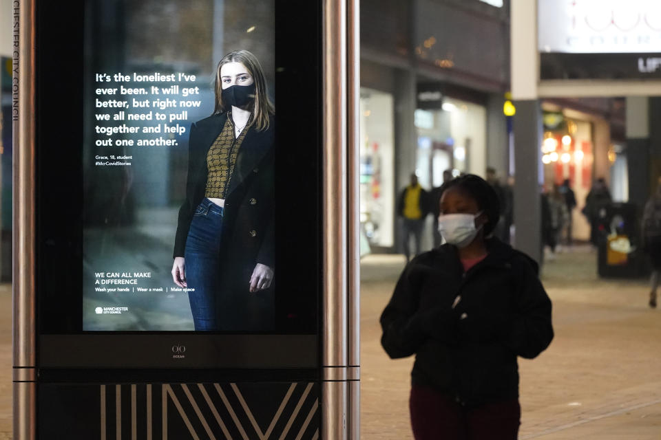 MANCHESTER, ENGLAND - DECEMBER 31: People walk past a government sponsored Covid-19 warning sign in the near deserted Manchester streets on December 31, 2020 in Manchester, England. New Year's Eve Celebrations have been curtailed in the UK this year dues to Coronavirus pandemic restrictions. With most of the UK in tiers three and four socialising is off limits. (Photo by Christopher Furlong/Getty Images)