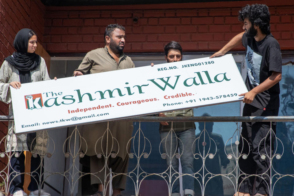 'The Kashmir Walla' reporters seen removing the office board (Faisal Bashir / SOPA / Lightrocket via Getty Images)