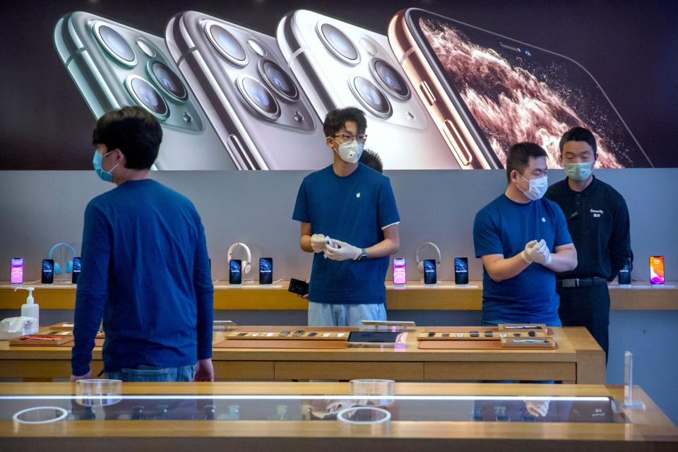 Employees at an Apple store in Beijing wearing masks to prevent the spread of the deadly coronavirus: AP