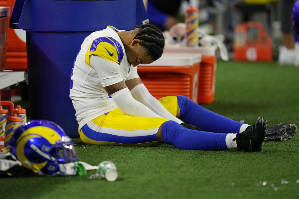Los Angeles Rams cornerback Cobie Durant (14) looks down as he sits on the ground near the bench during the first half of an NFL football game against the Dallas Cowboys Sunday, Oct. 29, 2023, in Arlington, Texas. (AP Photo/Julio Cortez)