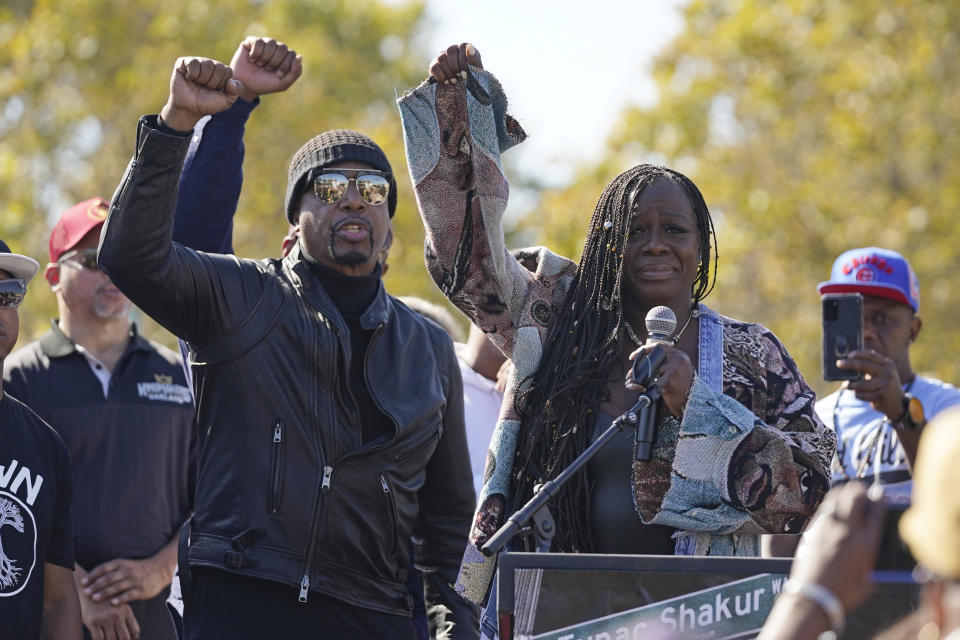 Sekyiwa Shakur, sister of Tupac Shakur, and MC Hammer raise their arms during a street renaming ceremony for her brother in Oakland, Calif., Friday, Nov. 3, 2023. A stretch of street in Oakland was renamed for Shakur, 27 years after the killing of the hip-hop luminary. A section of Macarthur Boulevard near where he lived in the 1990s is now Tupac Shakur Way, after a ceremony that included his family members and Oakland native MC Hammer. (AP Photo/Eric Risberg)