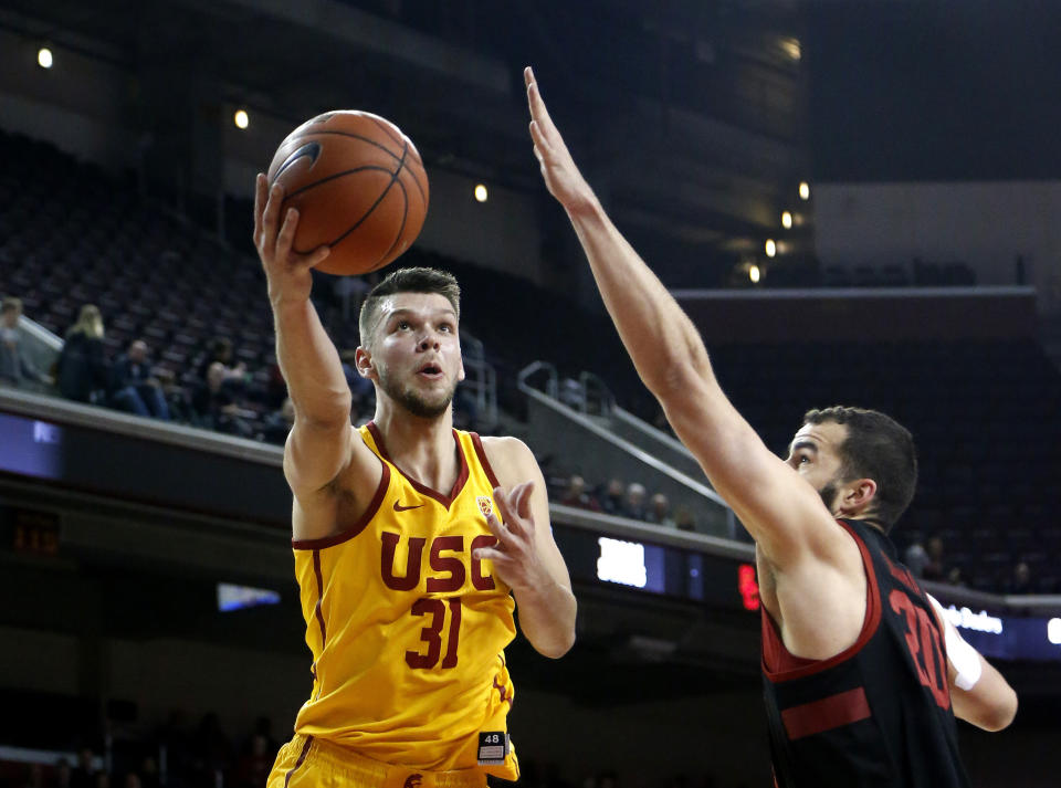FILE - In this Jan. 6, 2019. file photo, Southern California's Nick Rakocevic, left, goes to basket while defended by Stanford's Josh Sharma during the first half of an NCAA college basketball game in Los Angeles. In the midst of rocky seasons, crosstown rivals USC and UCLA meet Saturday at Galen Center. The Bruins have won four in a row in the series and are 8-4 at USC’s arena since it opened. “Coming off a two-game losing streak, we’re kind of hoping this is a game that we can bounce back,” Rakocevic said. “We want to be put in a good position for the rest of the Pac-12.” (AP Photo/Ringo H.W. Chiu, File)