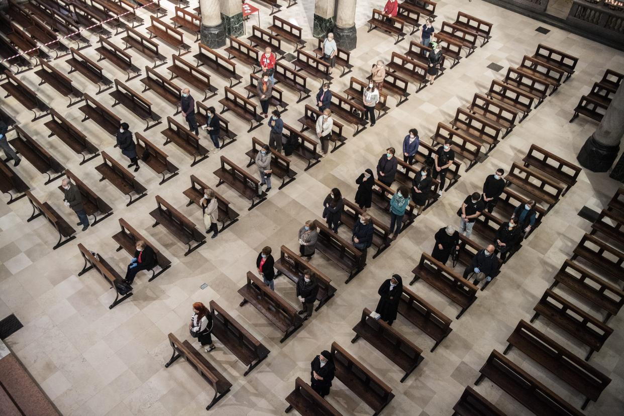 Faithful sitting in the benches, following the rules of social distancing, during a mass on the first day they were allowed during masses in Turin, Italy on Monday, May 18, 2020. Italy is slowly lifting sanitary restrictions after a two-month coronavirus lockdown.