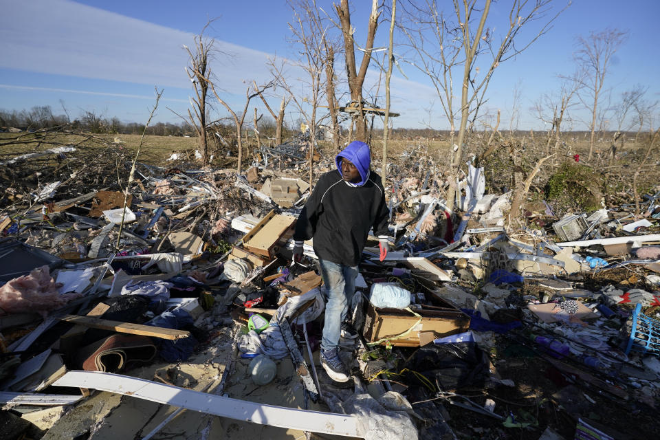 Tony Parrott looks through his daughter's damaged apartment unit after a tornado in Mayfield, Ky., on Saturday, Dec. 11, 2021. Tornadoes and severe weather caused catastrophic damage across several states late Friday, killing multiple people overnight. (AP Photo/Mark Humphrey)