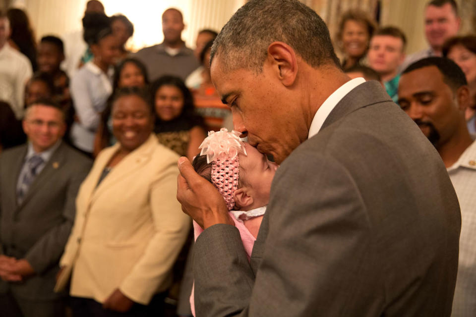 <p>“The President kisses a baby girl as he and the Vice President greeted wounded warriors and their families during their tour in the East Room of the White House on june 23, 2014.” (Pete Souza/The White House) </p>