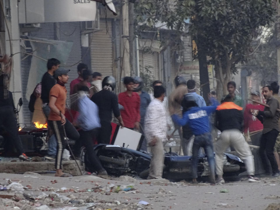 Una turba ataca una tienda y daña vehículos durante un brote de violencia entre dos grupos en Nueva Delhi, India, el martes 25 de febrero de 2020. (AP Foto)