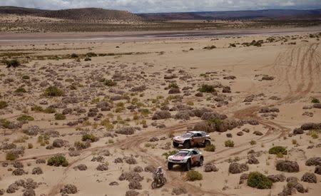Dakar Rally - 2017 Paraguay-Bolivia-Argentina Dakar rally - 39th Dakar Edition - Fifth stage from Tupiza to Oruro, Bolivia 06/01/17. Gregory Morat of France rides his KTM followed by Stephane Peterhansel of France drives his Peugeot with his copilot Jean Paul Ottret and Cyril Despres of France drives his Peugeot with his copilot David Costera. REUTERS/Ricardo Moraes