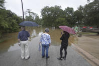 Local residents Harold and Carolyn Benson (l-r) along with Tara Richardson view the submerged Mary Xing bridge over Marys Creek that leads into Clear Creek as Tropical Storm Beta rainfall trained over the area Tuesday, Sept. 22, 2020, in Friendswood, Texas (Steve Gonzales/Houston Chronicle via AP)