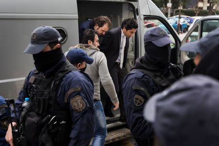 Two of the eight Turkish soldiers, who fled to Greece in a helicopter and requested political asylum after a failed military coup against the government, are escorted by police officers as they arrive at the Administrative Court of First Instance in Athens, Greece January 30, 2017. REUTERS/Alkis Konstantinidis