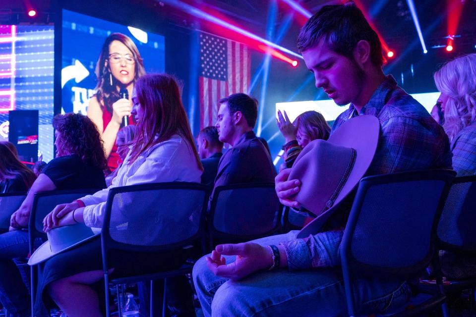 Attendees pray as Rep. Lauren Boebert, R-Colo., leads a prayer during the third day of AmericaFest 2021, hosted by Turning Point USA on Dec. 19, 2021, in Phoenix.