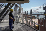 An employee of the Romanian grain handling operator Comvex controls the automated unloading of cereals from a barge in the Black Sea port of Constanta, Romania, Tuesday, June 21, 2022. While Romania has vocally embraced the ambitious goal of turning into a main hub for the export of agricultural products from Ukraine, economic experts and port operators in the country warn that it was much easier objective to set than to actually achieve. (AP Photo/Vadim Ghirda)