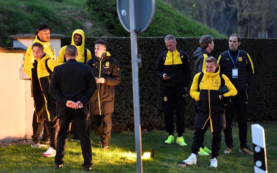 Head coach Thomas Tuchel, right, and players of Borussia Dortmund stand outside their team bus after it was damaged in an explosion before the Champions League quarterfinal - Credit: AP