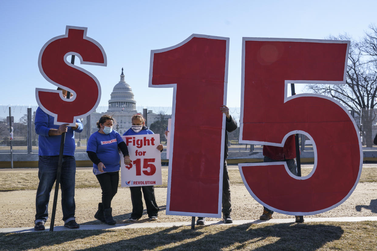 Activists appeal for a $15 minimum wage near the Capitol in Washington, Thursday, Feb. 25, 2021. The $1.9 trillion COVID-19 relief bill being prepped in Congress includes a provision that over five years would hike the federal minimum wage to $15 an hour. (AP Photo/J. Scott Applewhite)