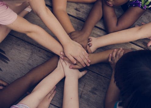 <span class="caption">Connecting with the climate risks that could be faced by future generations could influence support for better policies now. </span> <span class="attribution"><a class="link " href="https://www.shutterstock.com/image-photo/diverse-hands-join-together-on-wooden-642952270" rel="nofollow noopener" target="_blank" data-ylk="slk:Rawpixel.com/Shutterstock;elm:context_link;itc:0;sec:content-canvas">Rawpixel.com/Shutterstock</a></span>