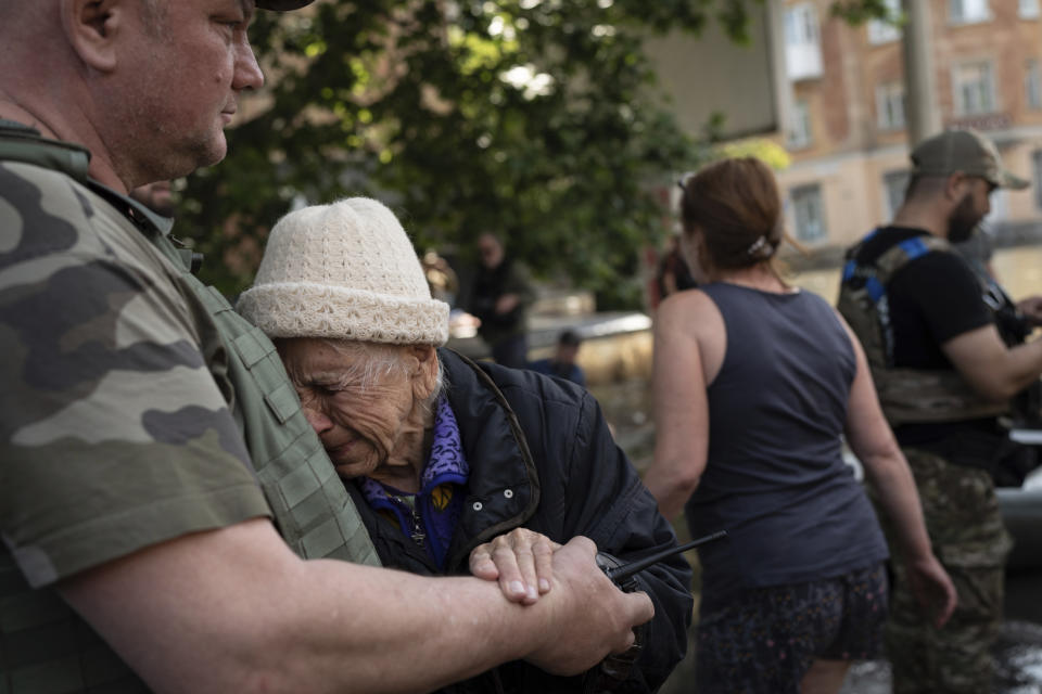 A woman cries as she is evacuated from a flooded neighborhood in Kherson, Ukraine, Wednesday, June 7, 2023 after the walls of the Kakhovka dam collapsed. Residents of southern Ukraine braced for a second day of swelling floodwaters on Wednesday as authorities warned that a Dnieper River dam breach would continue to unleash pent-up waters from a giant reservoir. (AP Photo/Roman Hrytsyna)