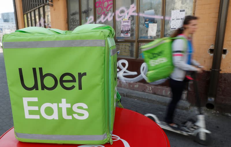 An Uber Eats courier rides a scooter in Kiev