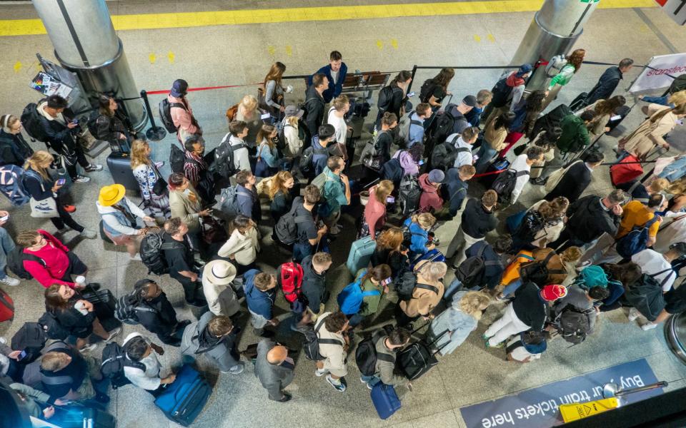 Queues to leave the train station at Stansted Airport in Essex built up as passengers arrived for their flights - Bav Media