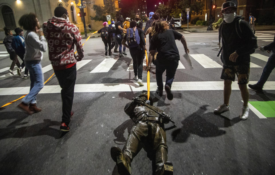 Protesters drag a figure pulled from the Confederate monument at the State Capitol down Salisbury Street in Raleigh, N.C., on Juneteenth, Friday, June 19, 2020. (Travis Long/The News & Observer via AP)