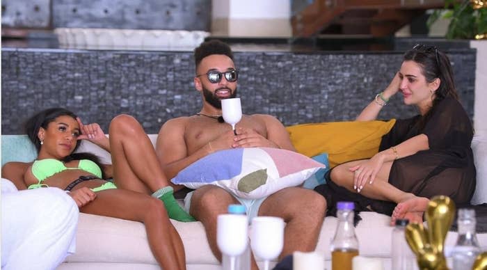 Bartise sits in between two women at a pool