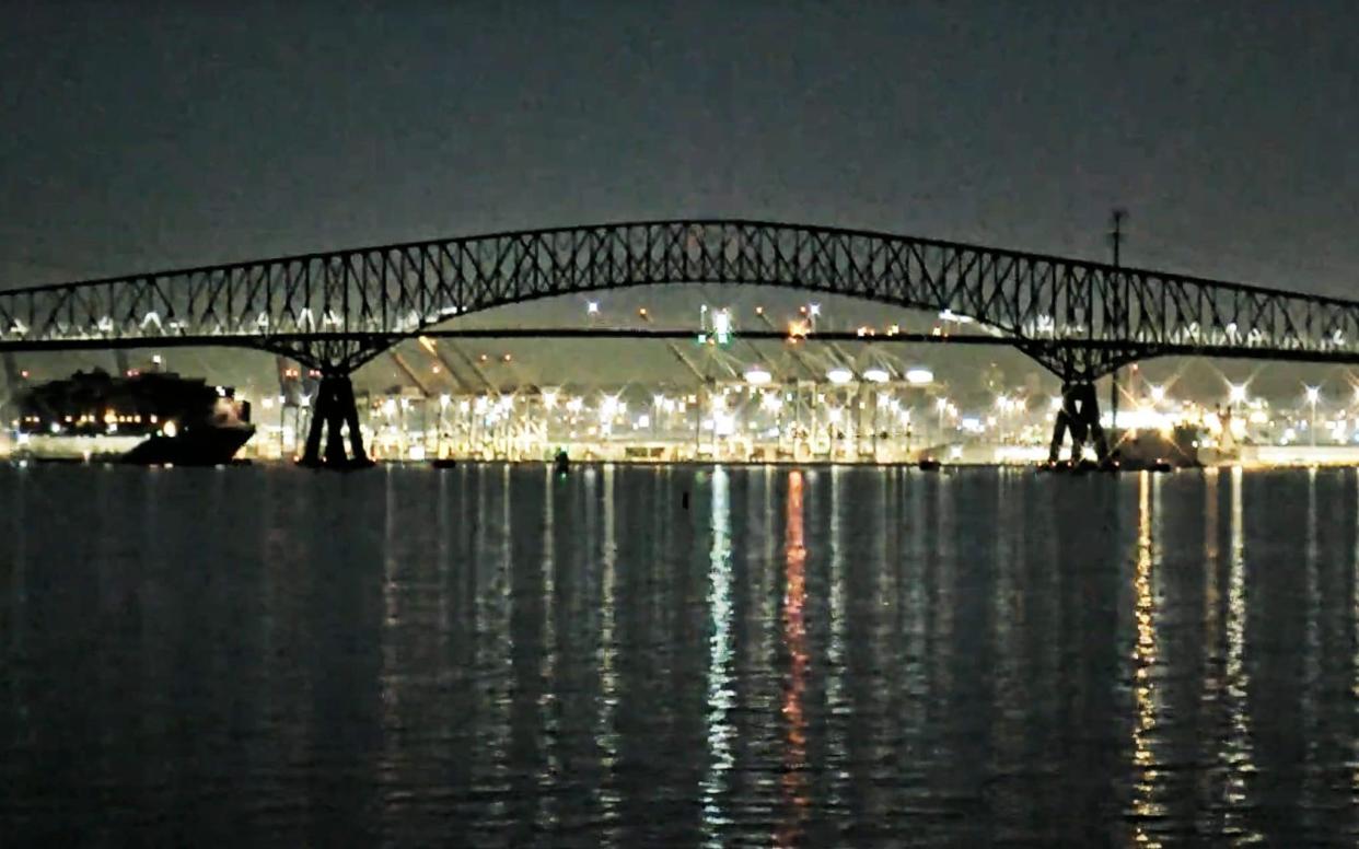 The cargo ship (left) heads towards the bridge