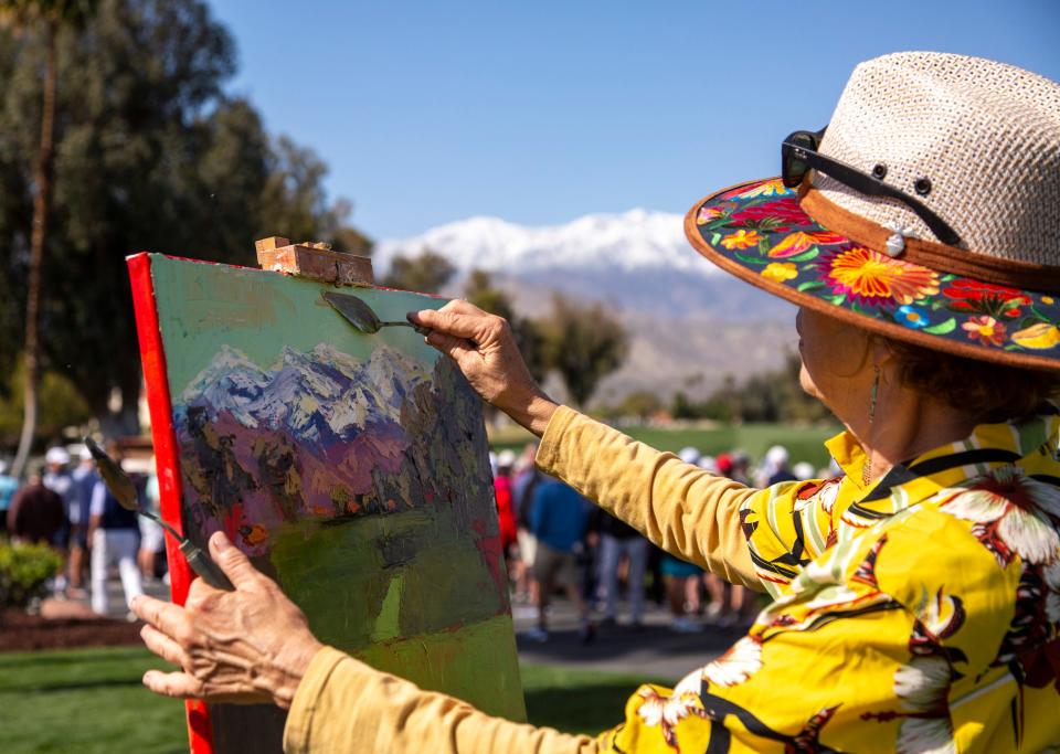 Artist Kathleen Strukoff adds color to the sky while painting the view of the first tee with the San Jacinto mountains in the background during the first round of the Galleri Classic in Rancho Mirage on Friday.