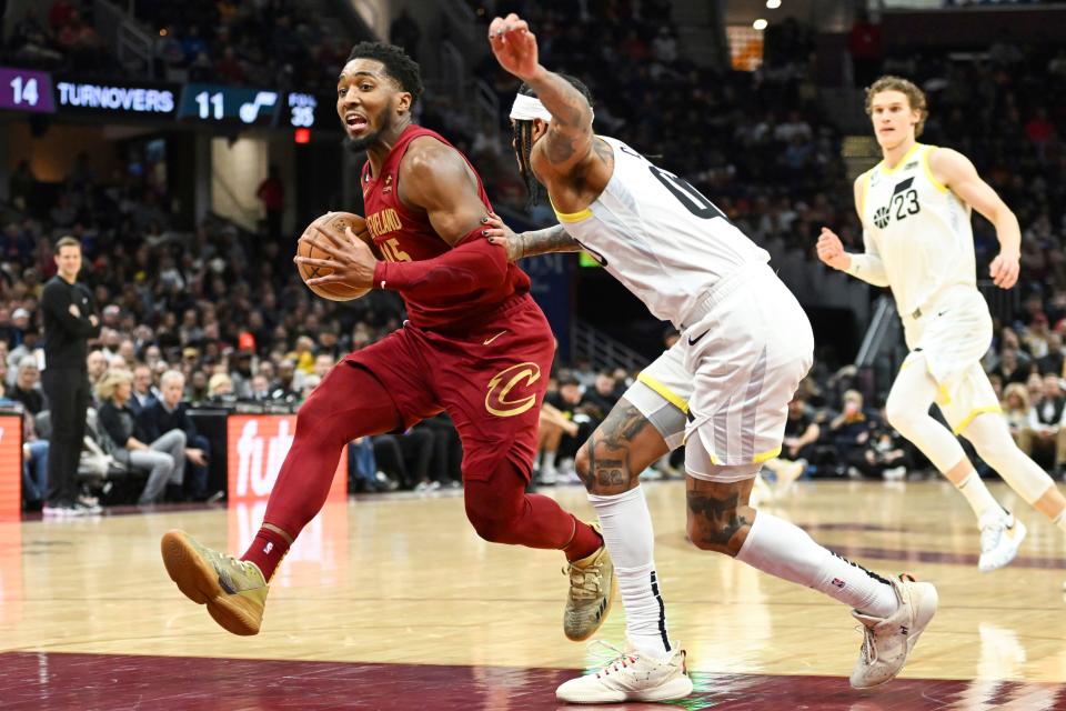 Cleveland Cavaliers guard Donovan Mitchell drives against Utah Jazz guard Jordan Clarkson during the second half of an NBA basketball game, Monday, Dec. 19, 2022, in Cleveland. (AP Photo/Nick Cammett)