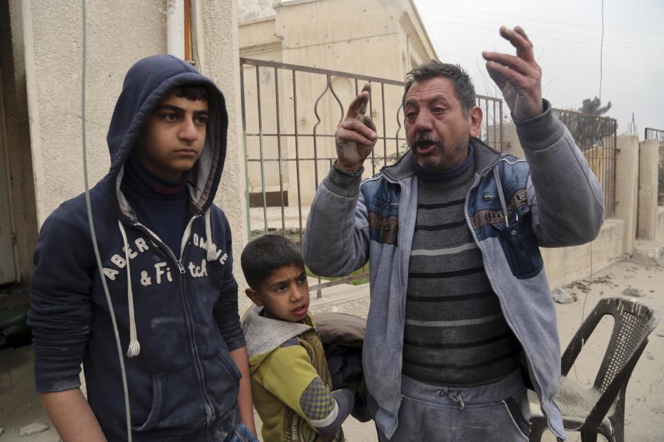 Thanon Yunus Yahya, right, chant slogans against Islamic State militia in a neighborhood recently liberated from the militia on the eastern side of Mosul, Iraq, Sunday, Jan. 15, 2017. Yahya claimed that his wife and son were previously executed by Islamic State militia. (AP Photo/ Khalid Mohammed)