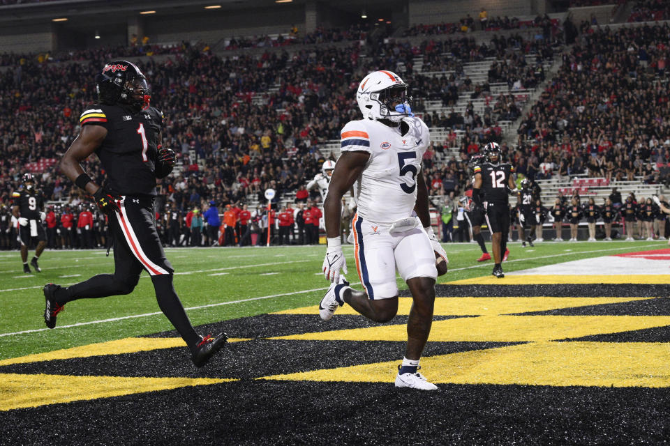 Virginia running back Kobe Pace (5) scores a touchdown past Maryland linebacker Jaishawn Barham (1) during the first half of an NCAA college football game Friday, Sept. 15, 2023, in College Park, Md. (AP Photo/Nick Wass)