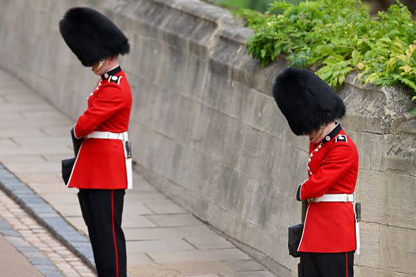 WINDSOR, ENGLAND - SEPTEMBER 19: Coldstream guards bow their heads at Windsor Castle on September 19, 2022 in Windsor, England. The committal service at St George's Chapel, Windsor Castle, took place following the state funeral at Westminster Abbey. A private burial in The King George VI Memorial Chapel followed. Queen Elizabeth II died at Balmoral Castle in Scotland on September 8, 2022, and is succeeded by her eldest son, King Charles III. (Photo by Leon Neal/Getty Images)