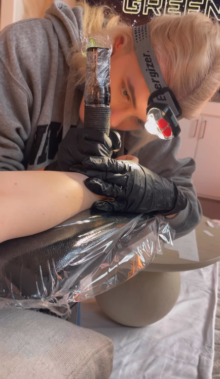 tattoo artist working on taylor's arm