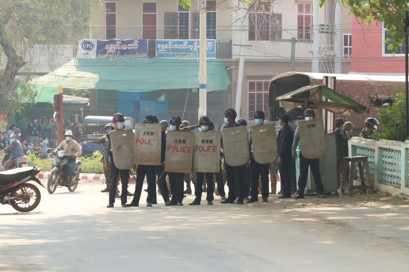 Security force officers hold shields in Nyaung-U