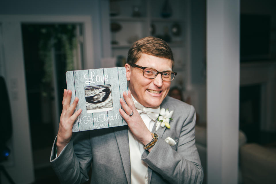 Charlie holds up the framed sonogram of his future daughter. (Photo: James Brindley Wedding Photography)