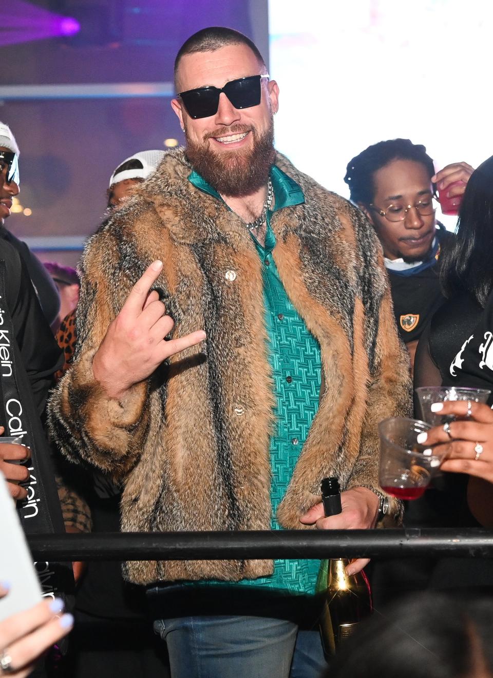 Travis Kelce wearing a fur jacket.