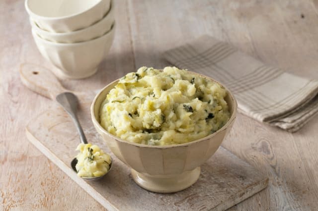 Colcannon potato mash in cream faceted bowl with metal spoon